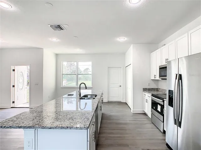 a view of kitchen with windows and refrigerator