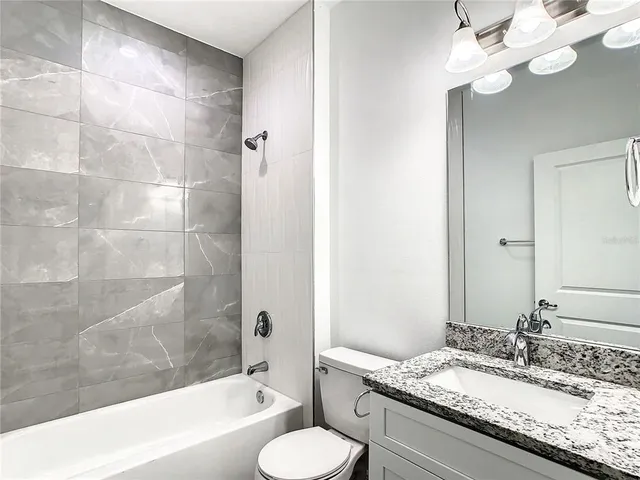 a bathroom with a granite countertop double vanity sink and a mirror