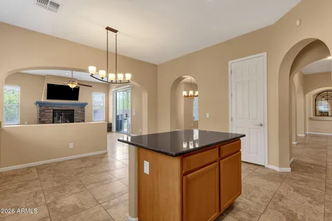 a kitchen with kitchen island granite countertop a sink a counter top space and cabinets