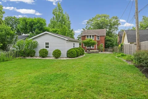 a view of a house with a yard and potted plants