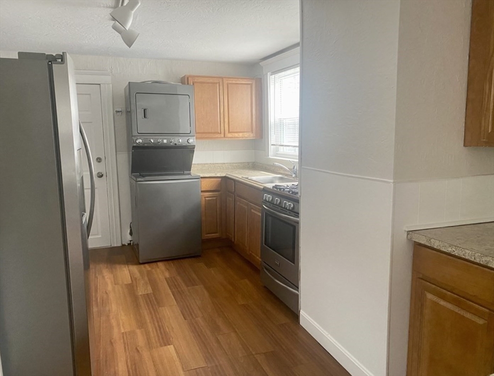 13 Sculpin Way, Unit 1 Swampscott, MA 01907 - Photo 5 of 9 a kitchen with a refrigerator sink and cabinets