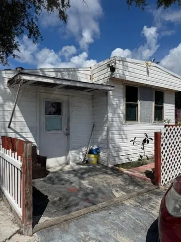 a view of a house with a wooden fence