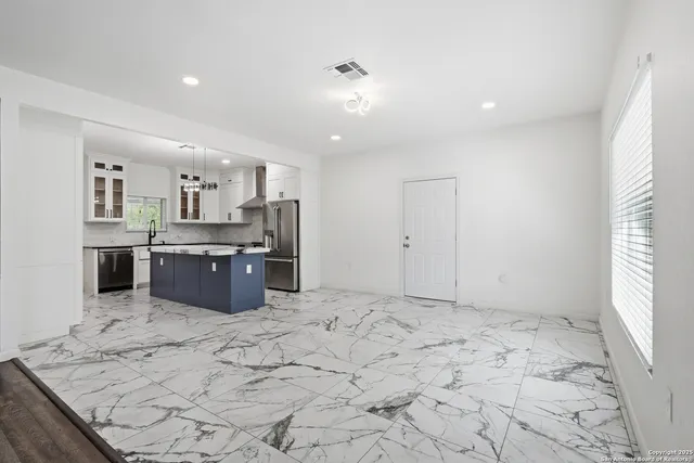 a large kitchen with stainless steel appliances granite countertop a sink and cabinets