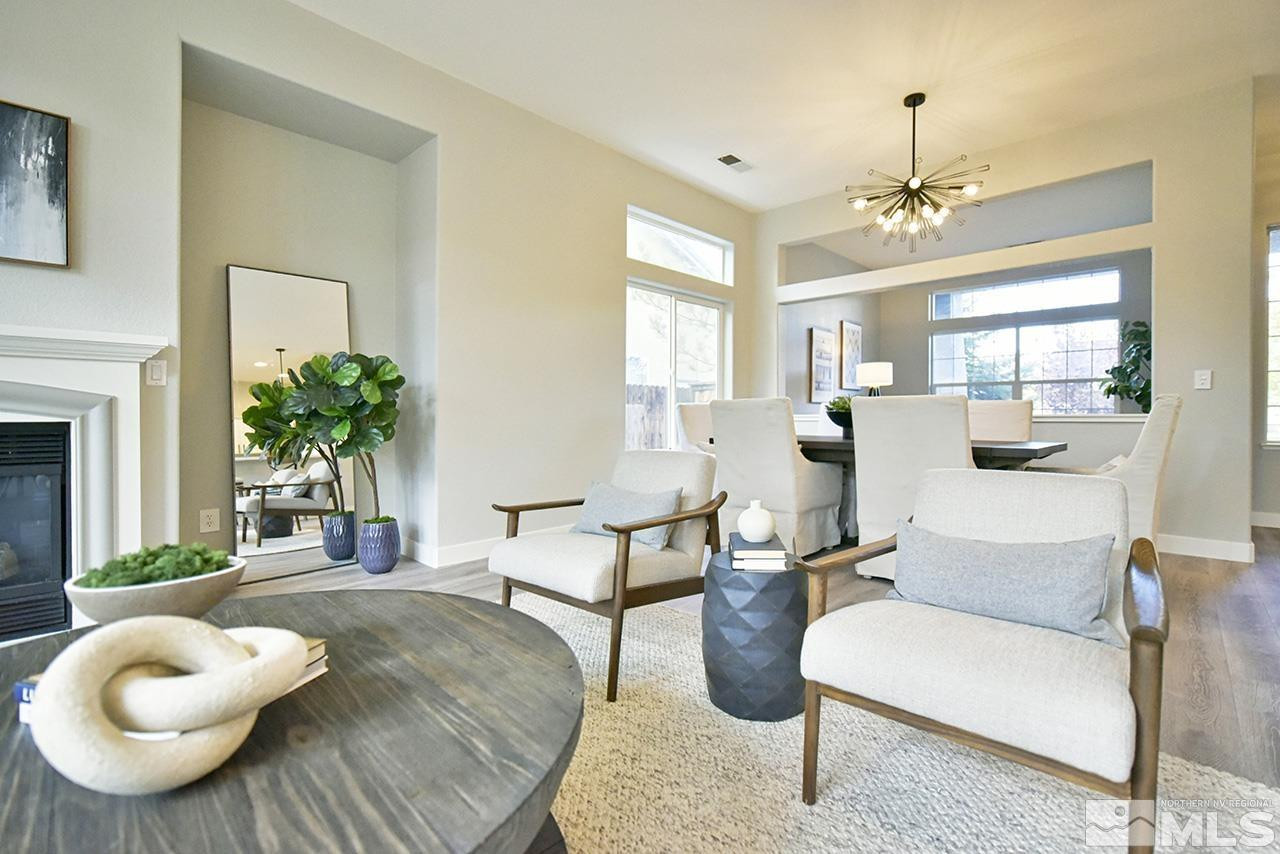 1680 Caliterra Way Reno, NV 89521 - Photo 11 of 34 a living room with furniture a chandelier and a fireplace
