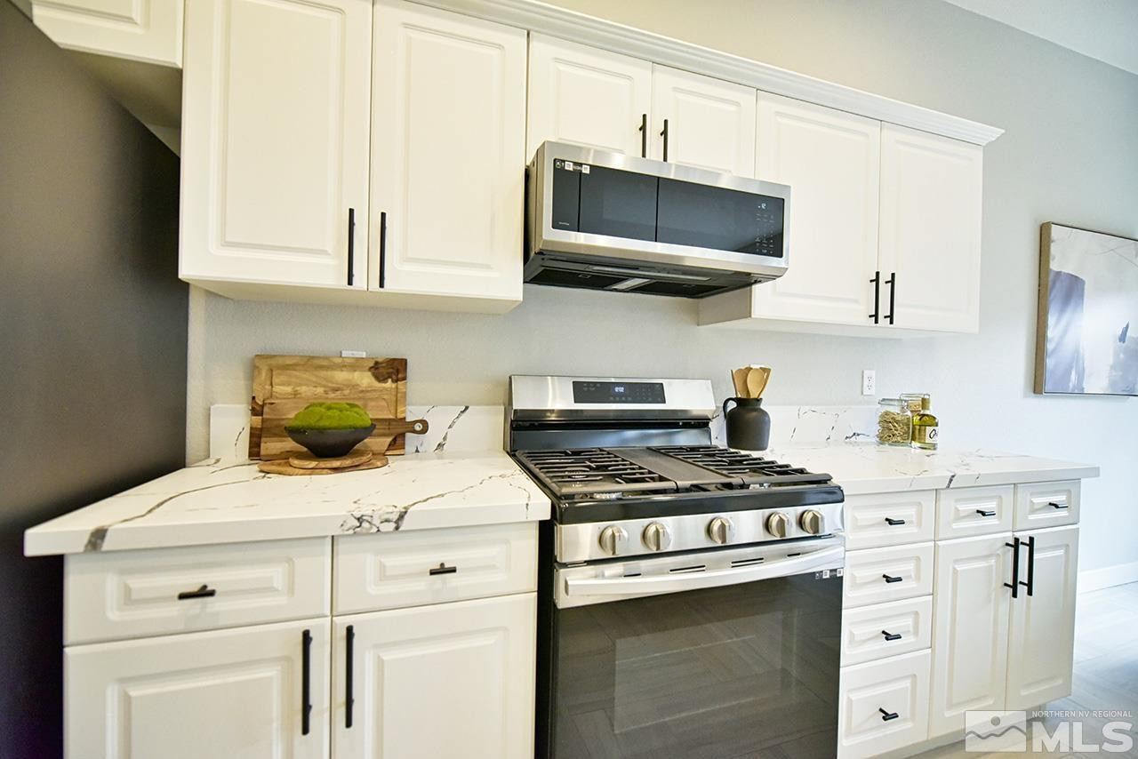 1680 Caliterra Way Reno, NV 89521 - Photo 15 of 34 a kitchen with stainless steel appliances a stove a microwave and cabinets