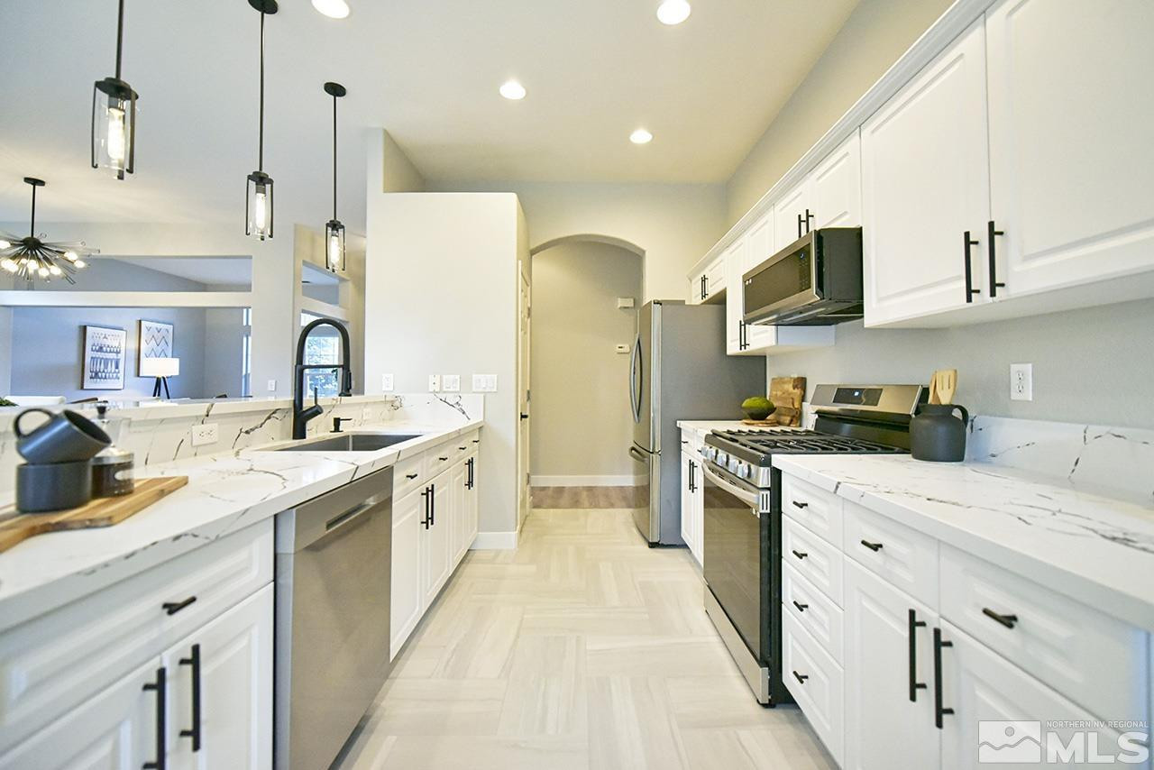 1680 Caliterra Way Reno, NV 89521 - Photo 16 of 34 a kitchen with stainless steel appliances granite countertop a sink and cabinets