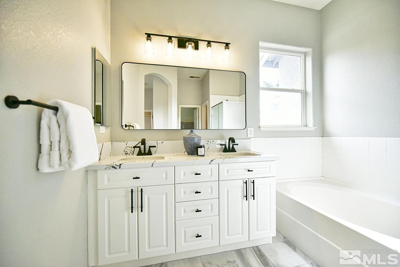 1680 Caliterra Way Reno, NV 89521 - Photo 28 of 34 a spacious bathroom with a double vanity sink mirror and bathtub