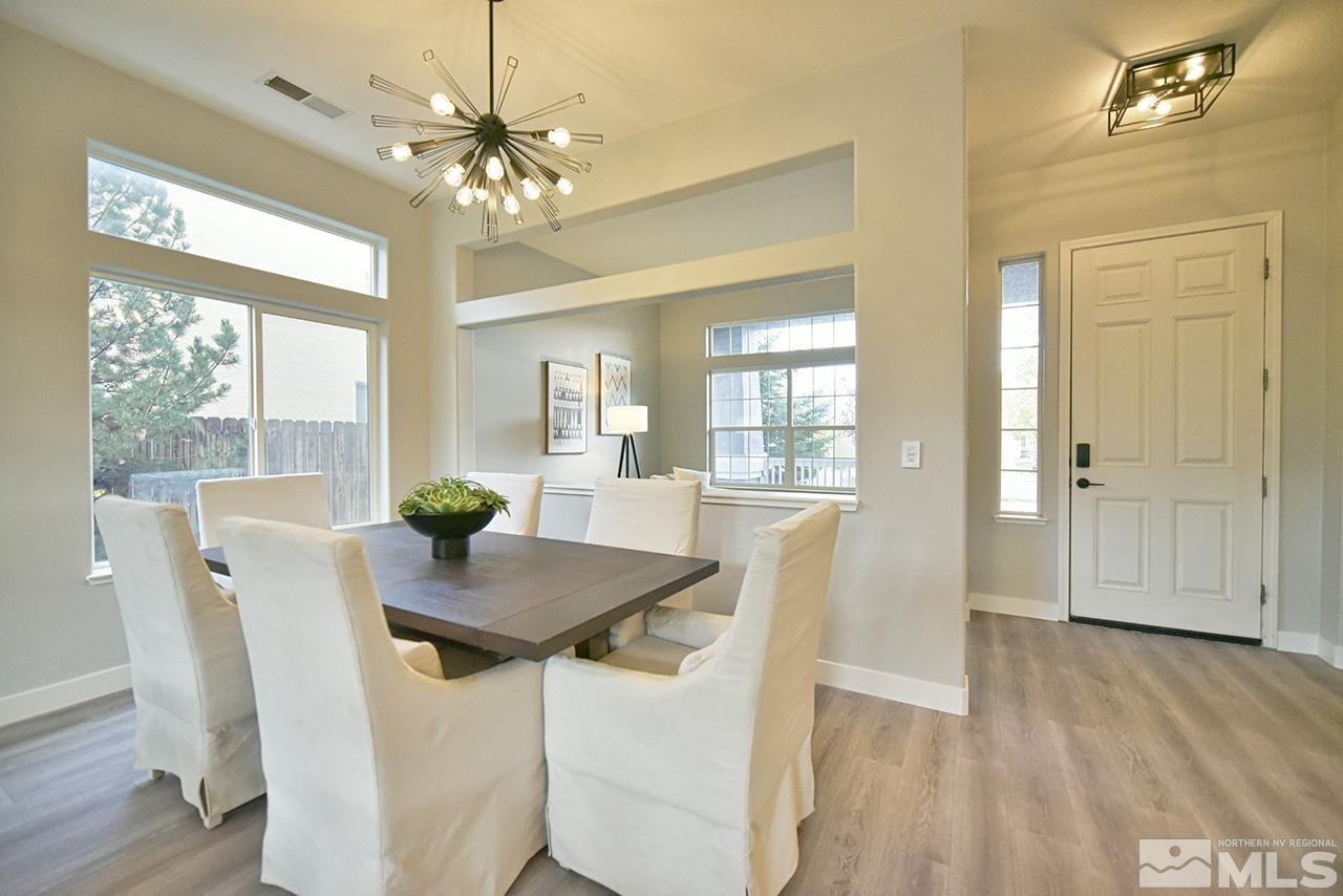 1680 Caliterra Way Reno, NV 89521 - Photo 7 of 34 a dining room with furniture a chandelier and wooden floor