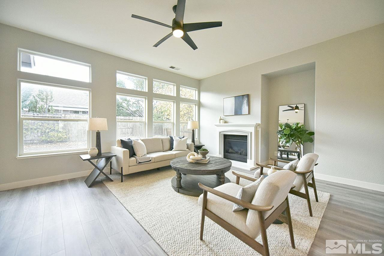 1680 Caliterra Way Reno, NV 89521 - Photo 10 of 34 a living room with furniture a large window and a fireplace