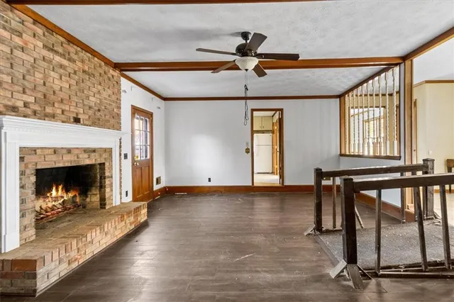 a view of an empty room with exposed radiator and fireplace