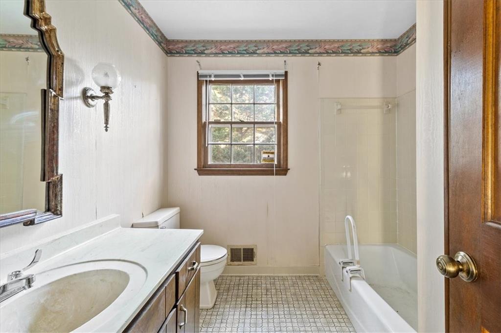 2075 Pinewood Drive Covington, GA 30016 - Photo 27 of 37 a bathroom with a granite countertop sink a toilet and shower