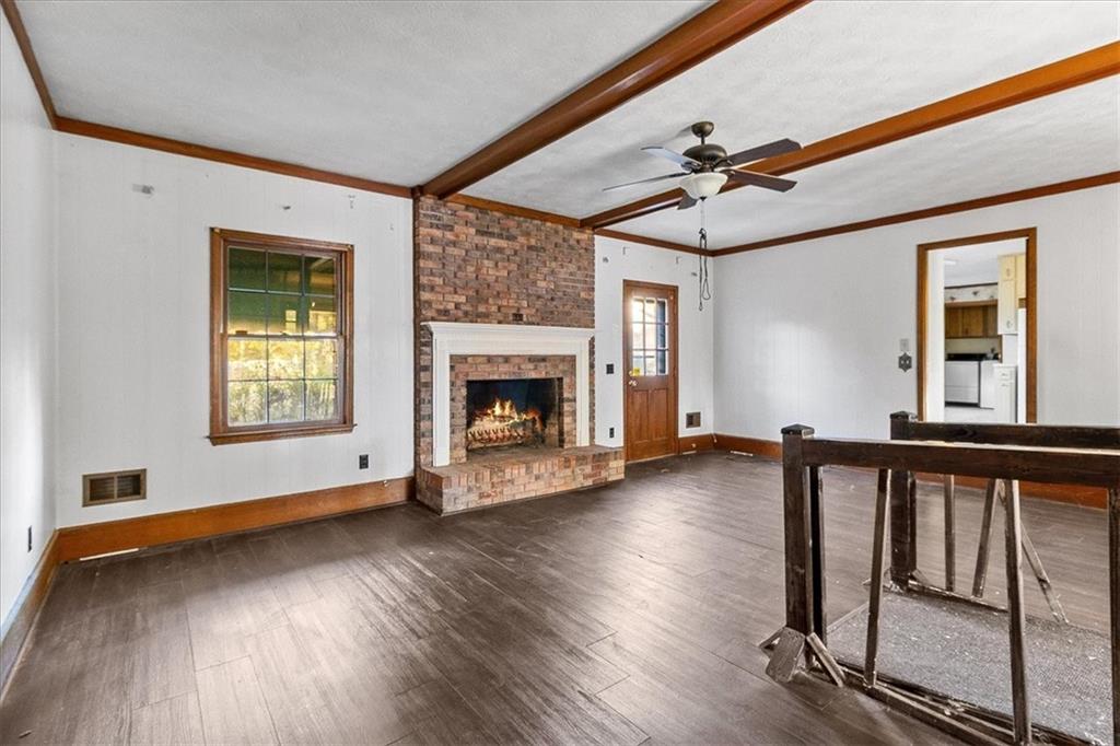 2075 Pinewood Drive Covington, GA 30016 - Photo 9 of 37 a view of an empty room with wooden floor fireplace and a window