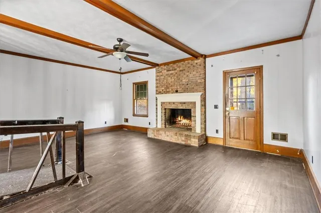 a view of an empty room with a fireplace and a window