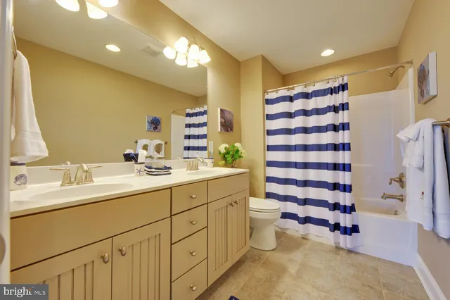 a bathroom with a double vanity sink toilet and shower