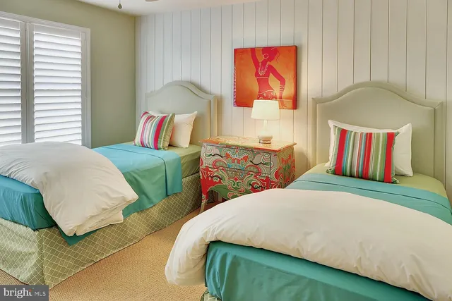 a bedroom with two beds and painting on the wall