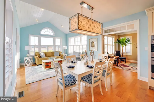 a view of a dining room with furniture a chandelier and wooden floor