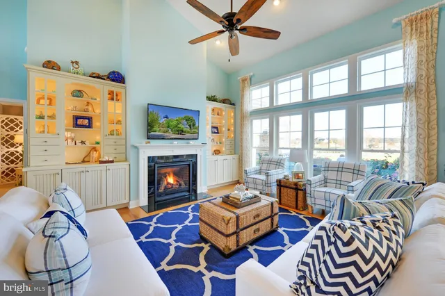 a living room with furniture a fireplace and a floor to ceiling window