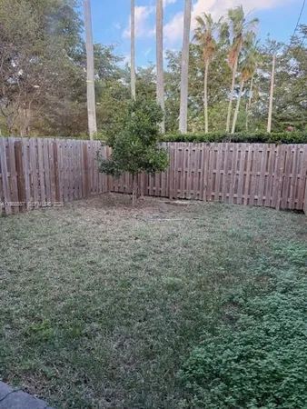 a view of a yard with wooden fence
