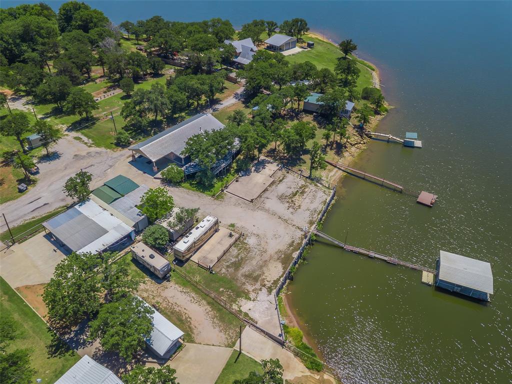 566 Selma Park Road Bowie, TX 76230 - Photo 39 of 40 Waterfront property featuring multiple docks, a private boat house, and mature trees