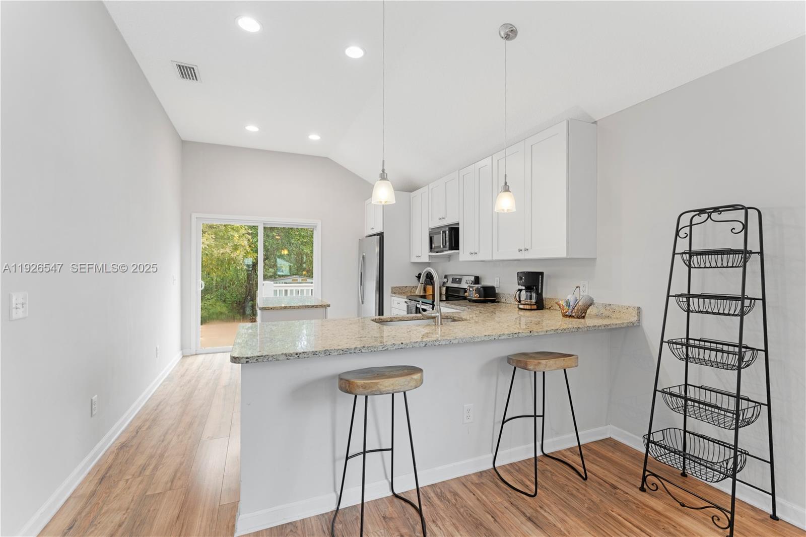 2 Poinciana Cove Road St. Augustine, FL 32084 - Photo 17 of 44 a kitchen with stainless steel appliances granite countertop a stove top oven a sink dishwasher a dining table and chairs with wooden floor