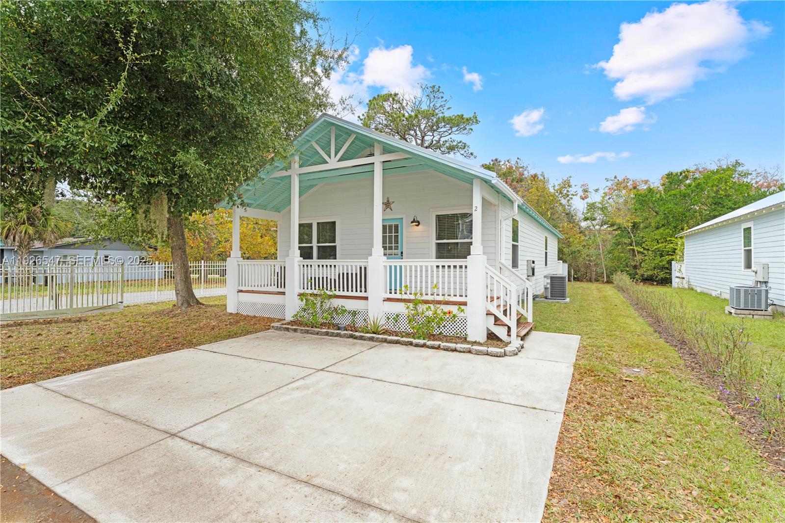 2 Poinciana Cove Road St. Augustine, FL 32084 - Photo 5 of 44 a view of a white house with large windows and a small yard