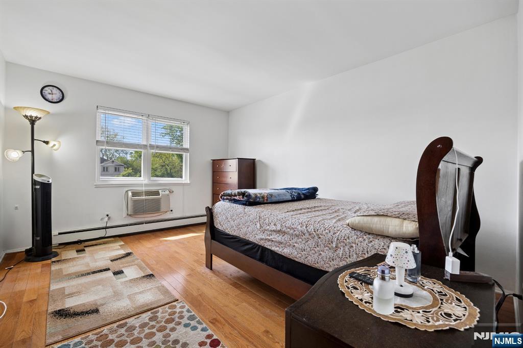 747 Riverside Avenue, Unit C1 Lyndhurst, NJ 07071 - Photo 12 of 16 a bedroom with a bed and dresser with mirror
