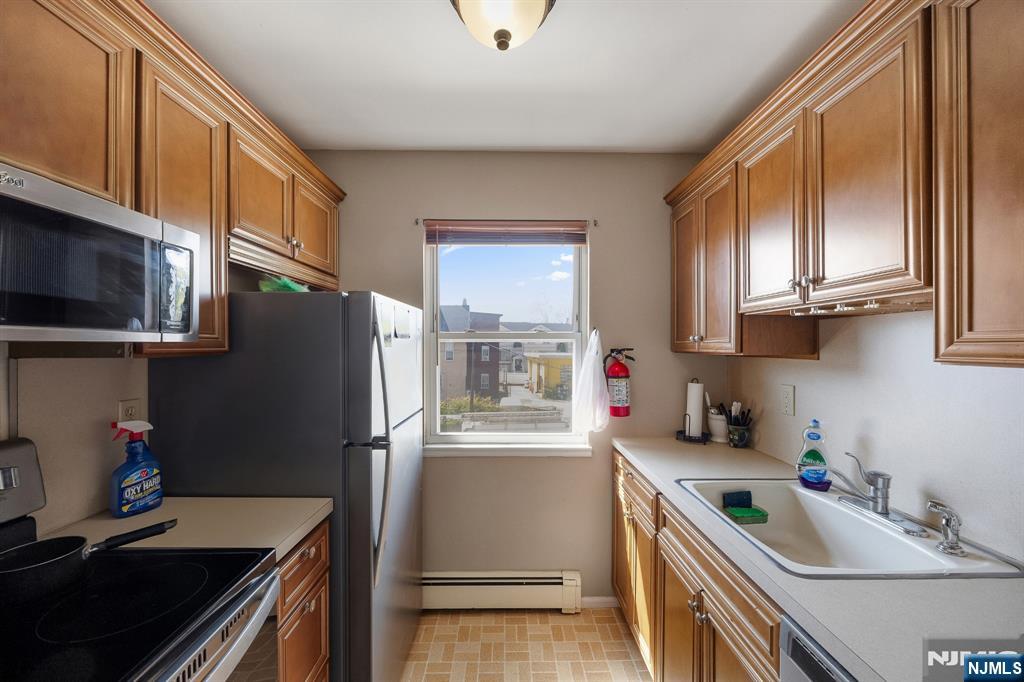 747 Riverside Avenue, Unit C1 Lyndhurst, NJ 07071 - Photo 6 of 16 a kitchen with stainless steel appliances granite countertop a refrigerator sink and stove