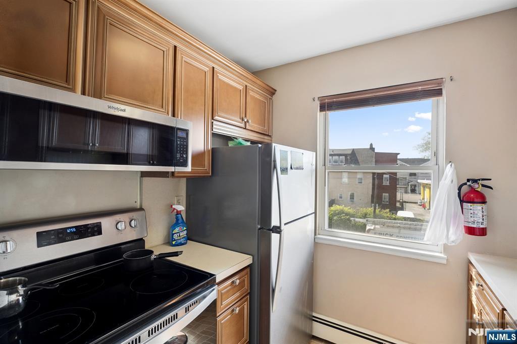 747 Riverside Avenue, Unit C1 Lyndhurst, NJ 07071 - Photo 7 of 16 a kitchen with stainless steel appliances a refrigerator and a stove top oven