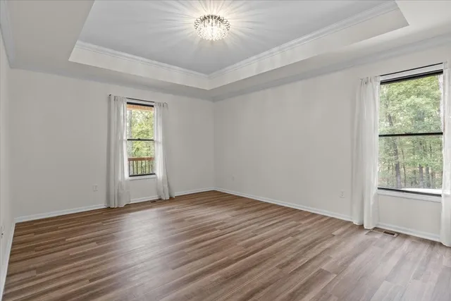 a view of an empty room with wooden floor