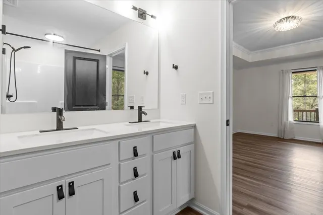 an empty room with wooden floor chandelier fan and windows