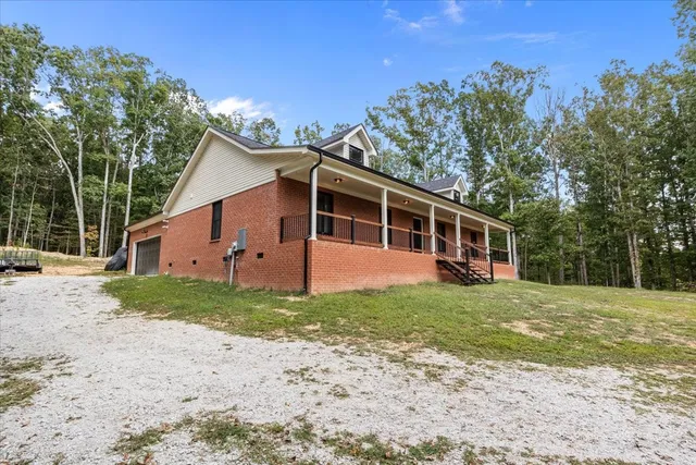 a front view of a house with a yard and trees