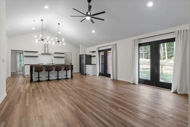 a view of a livingroom with furniture chandelier fan and wooden floor