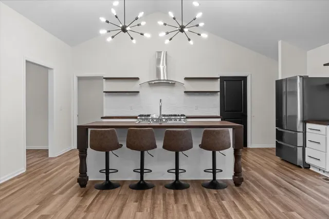a view of kitchen with granite countertop wooden floor and stainless steel appliances