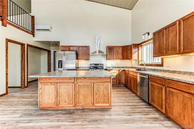 a large kitchen with stainless steel appliances granite countertop a stove a sink dishwasher and a refrigerator
