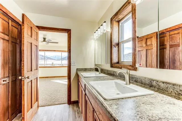 a bathroom with a granite countertop sink and a large mirror