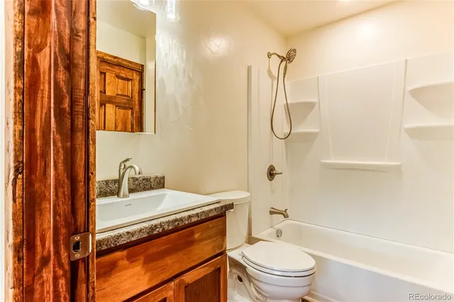 a bathroom with a granite countertop sink toilet and shower