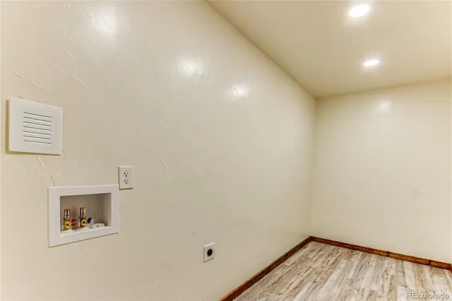 a view of a hallway with wooden floor and a window