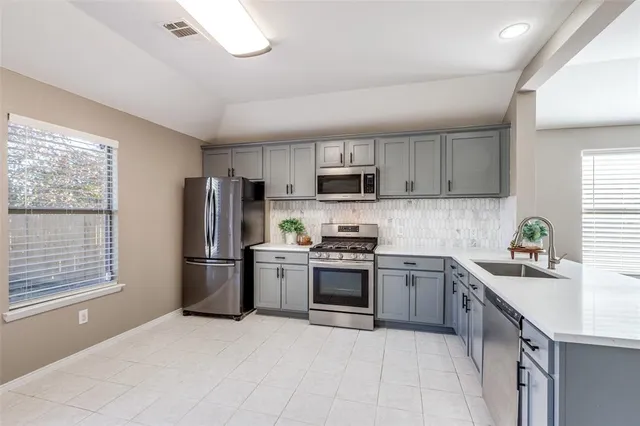 a kitchen with a refrigerator a sink and a stove top oven