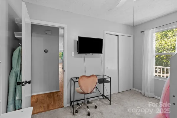 a view of a workspace with furniture and a window