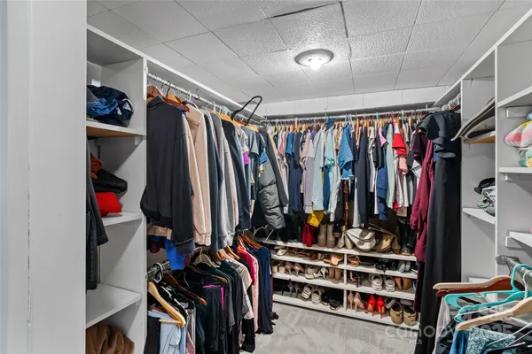 a view of walk in closet with clothes and shoes