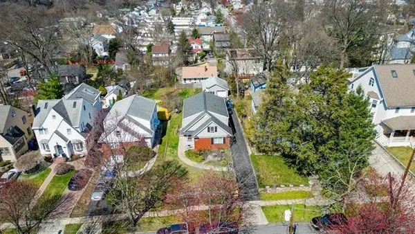 an aerial view of residential houses with outdoor space and street view