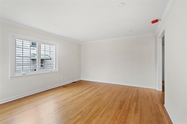 238 Springfield Avenue, Unit 1 Rutherford, NJ 07070 - Photo 3 of 33 a view of an empty room with wooden floor and a window
