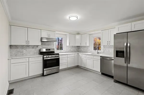 a kitchen with white cabinets and stainless steel appliances