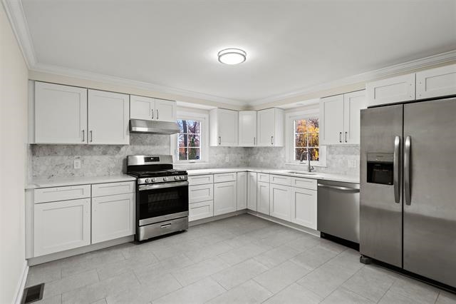 238 Springfield Avenue, Unit 1 Rutherford, NJ 07070 - Photo 7 of 33 a kitchen with white cabinets and stainless steel appliances