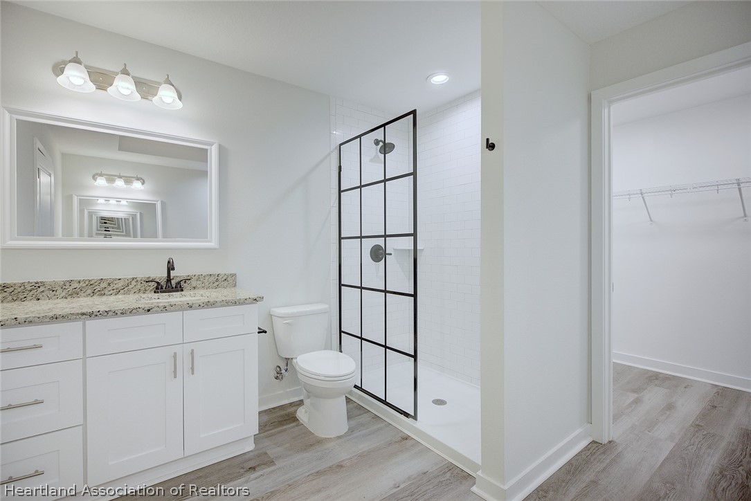 111 Vale Court Sebring, FL 33876 - Photo 21 of 40 a bathroom with a granite countertop toilet sink and mirror