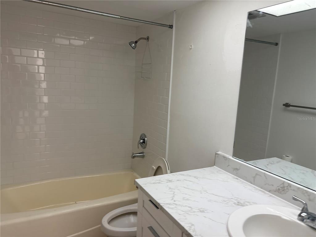 5157 Silent Loop, Unit 115 New Port Richey, FL 34652 - Photo 16 of 18 a bathroom with a granite countertop sink toilet and bathtub