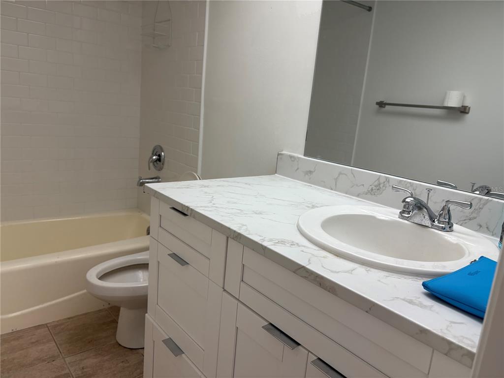 5157 Silent Loop, Unit 115 New Port Richey, FL 34652 - Photo 17 of 18 a bathroom with a sink a toilet and a bathtub