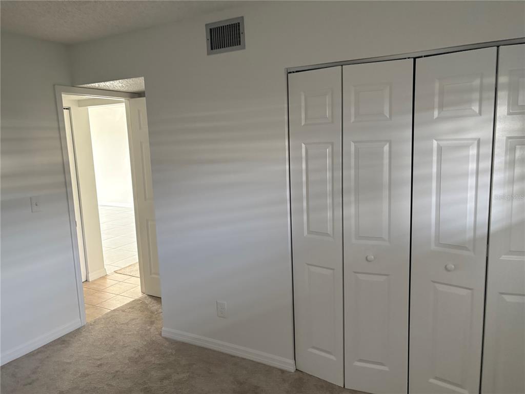 5157 Silent Loop, Unit 115 New Port Richey, FL 34652 - Photo 18 of 18 a bathroom with a glass shower door