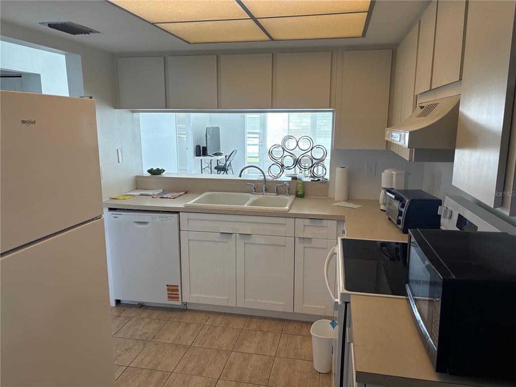 5157 Silent Loop, Unit 115 New Port Richey, FL 34652 - Photo 7 of 18 a kitchen with a sink cabinets and appliances