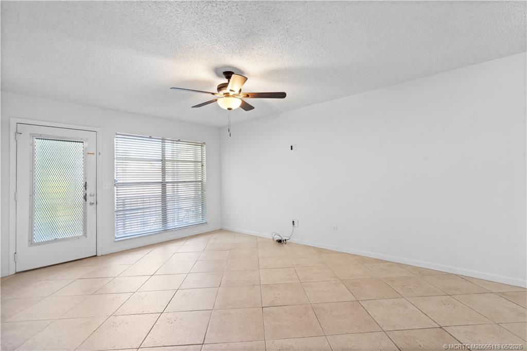 2118 Southeast Edler Drive, Unit B Stuart, FL 34994 - Photo 6 of 20 an empty room with windows and ceiling fan